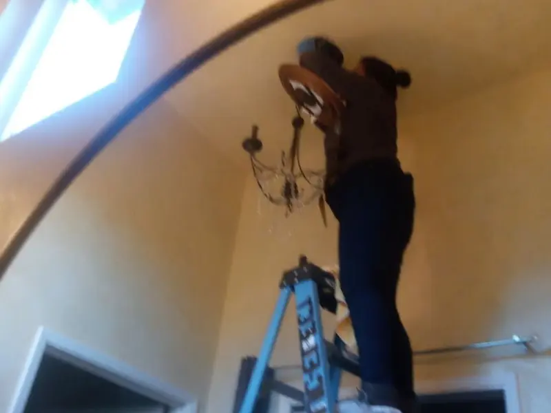 Electrician installing a chandelier in a French Valley residence